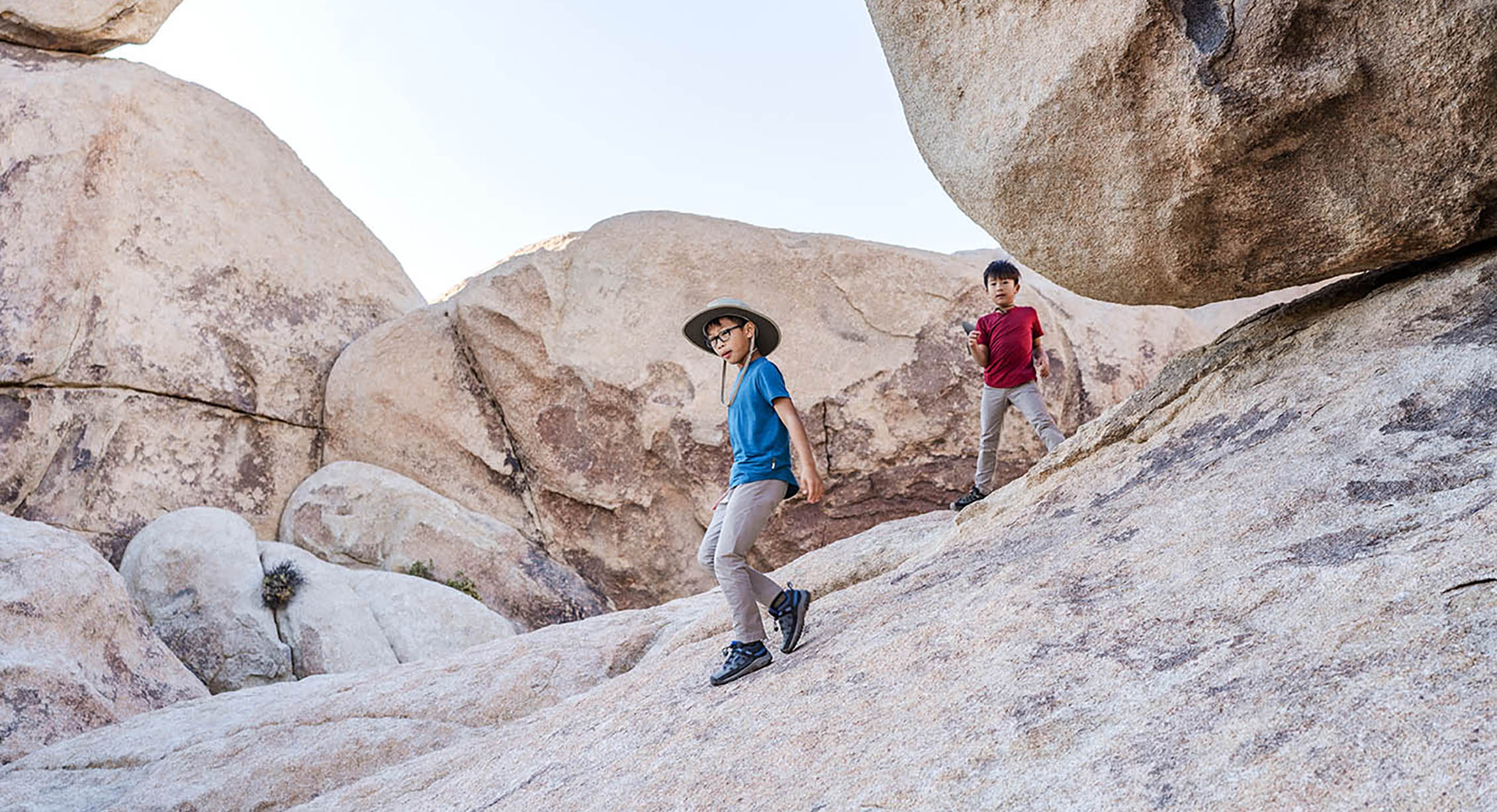 Kids scrambling on rocks in Joshua Tree National Park