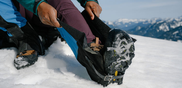 Person gearing up to hike on a snowy mountain