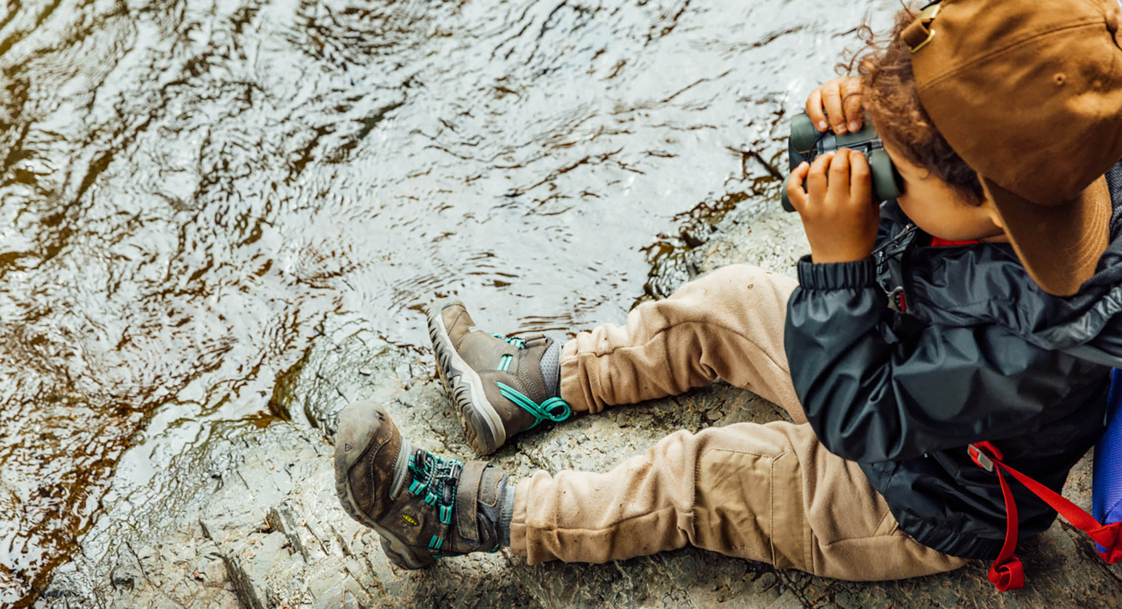 A toddler playing I Spy with binoculars