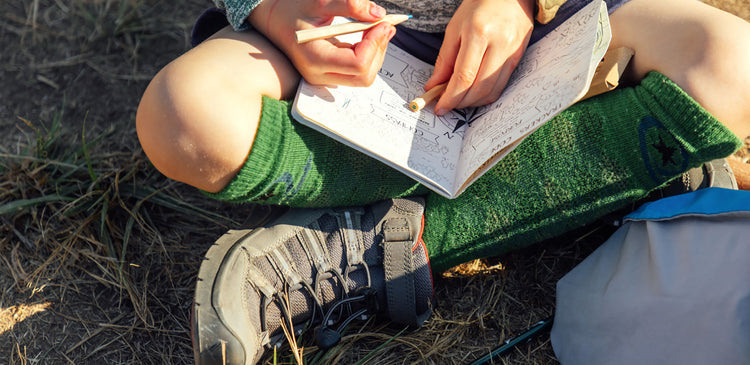 A child writing in a nature journal