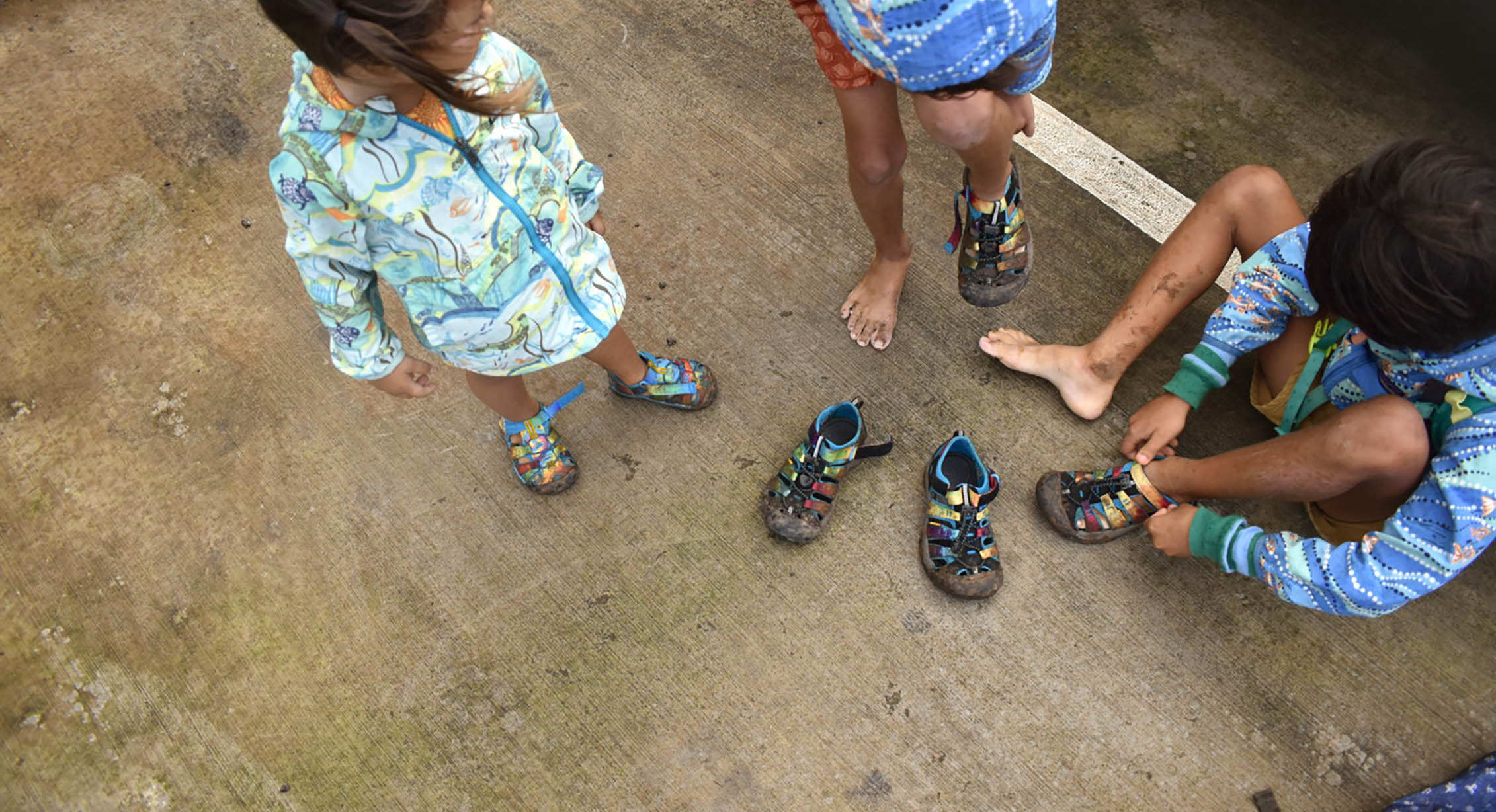 kids putting sandals on at the beach