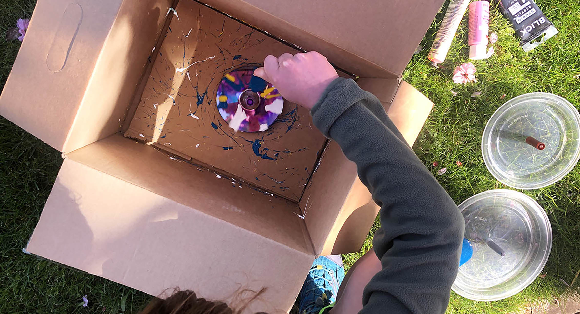 A child making spin art with repurposed objects