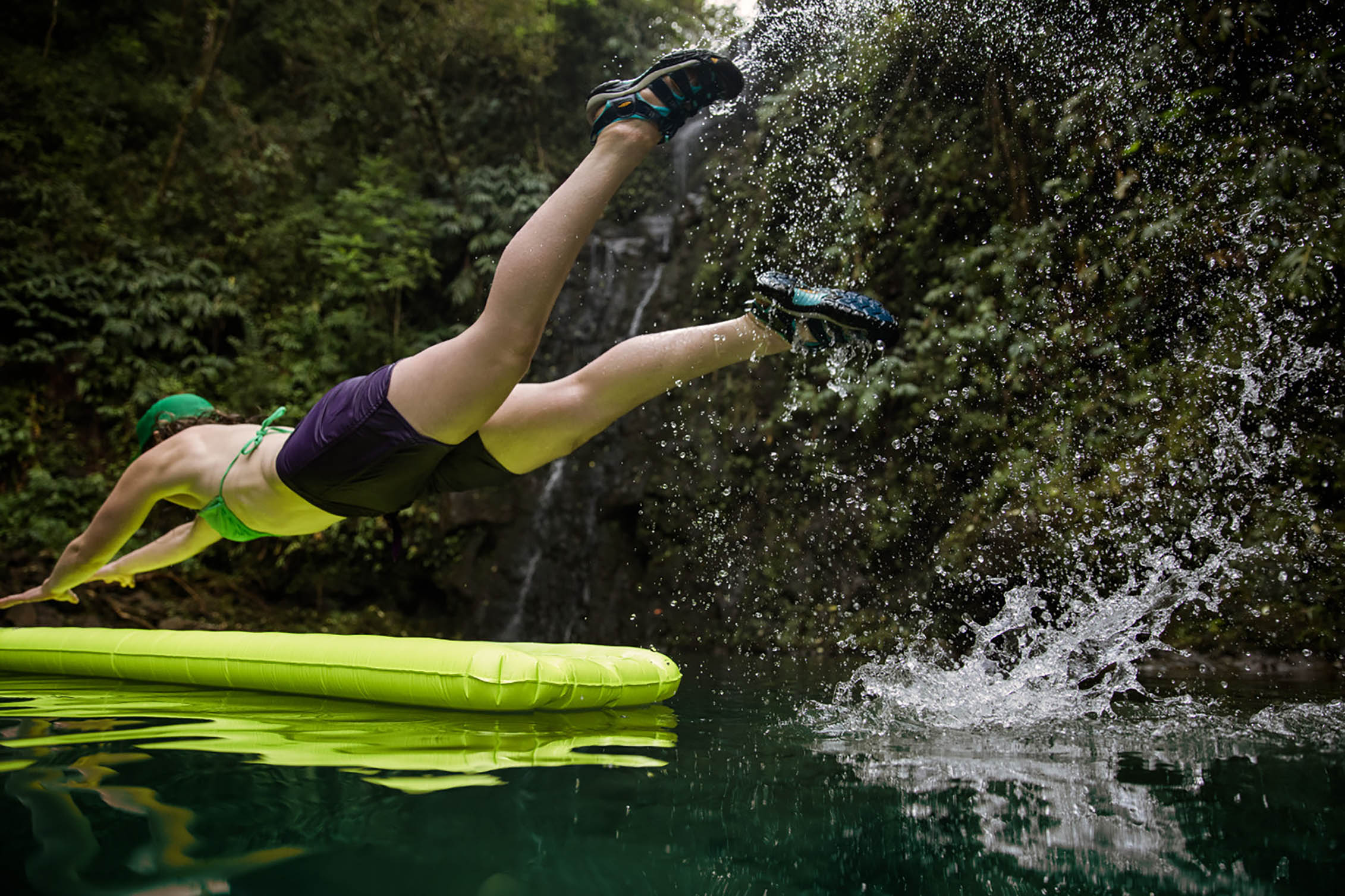 A woman jumping on a raft in the water