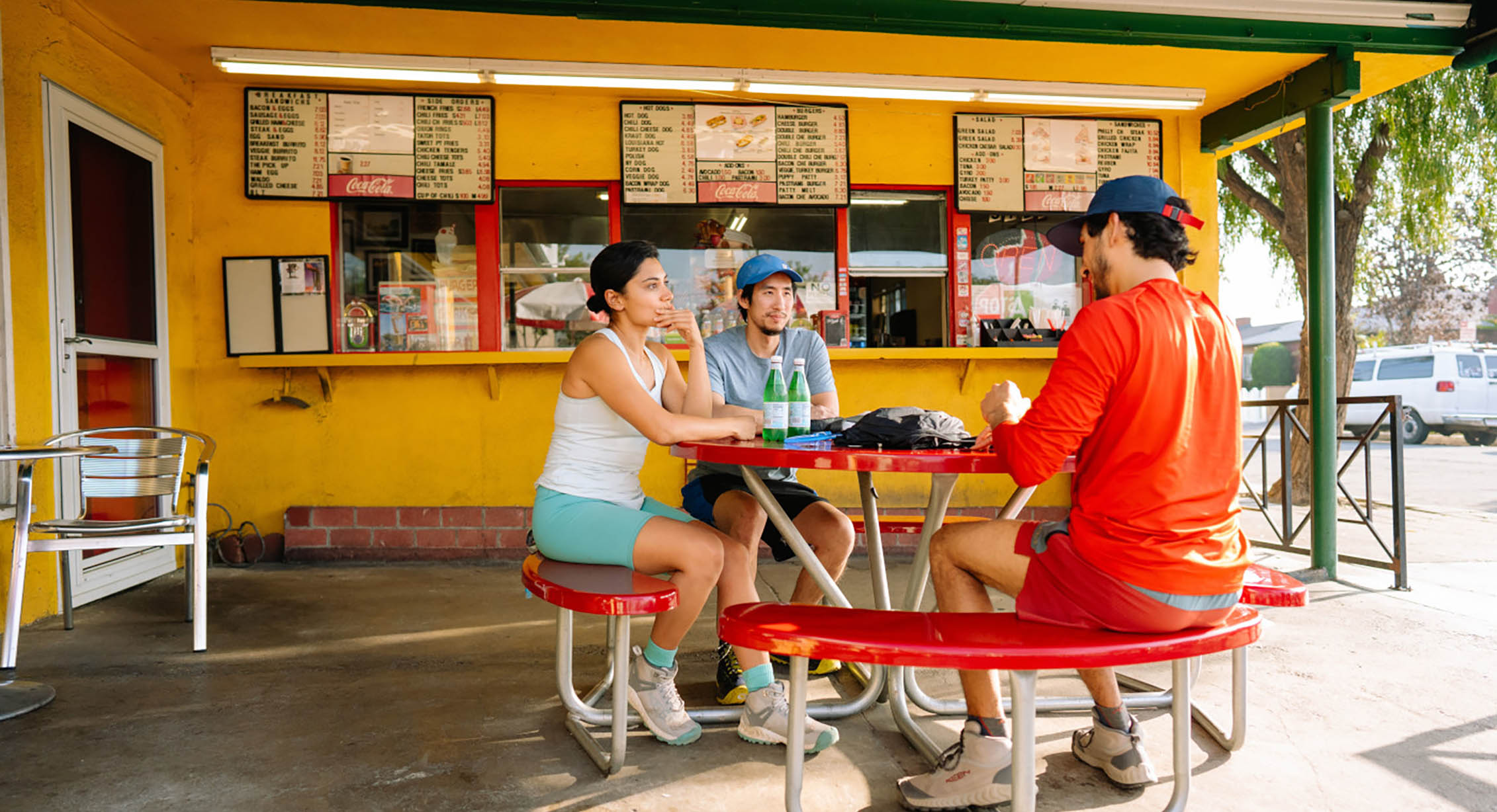 a group of people sit outside at a hamburger stand