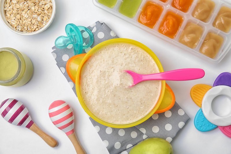 A mother making a variety of her own baby food in a kitchen