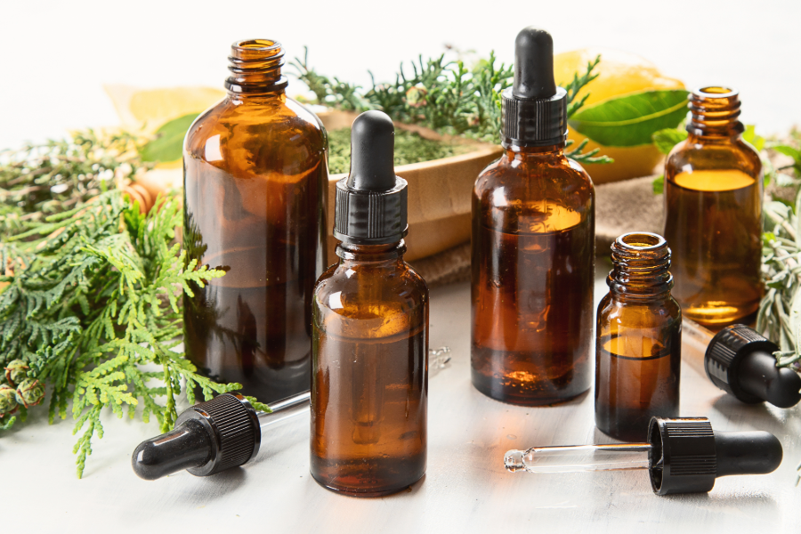 Bottles of essential oils and fresh herbs