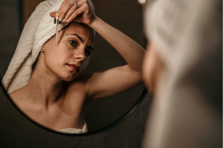 A woman applying essential oil during a facial massage