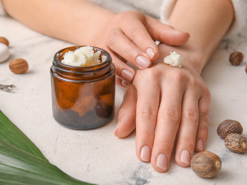 Woman applying shea butter to her skin