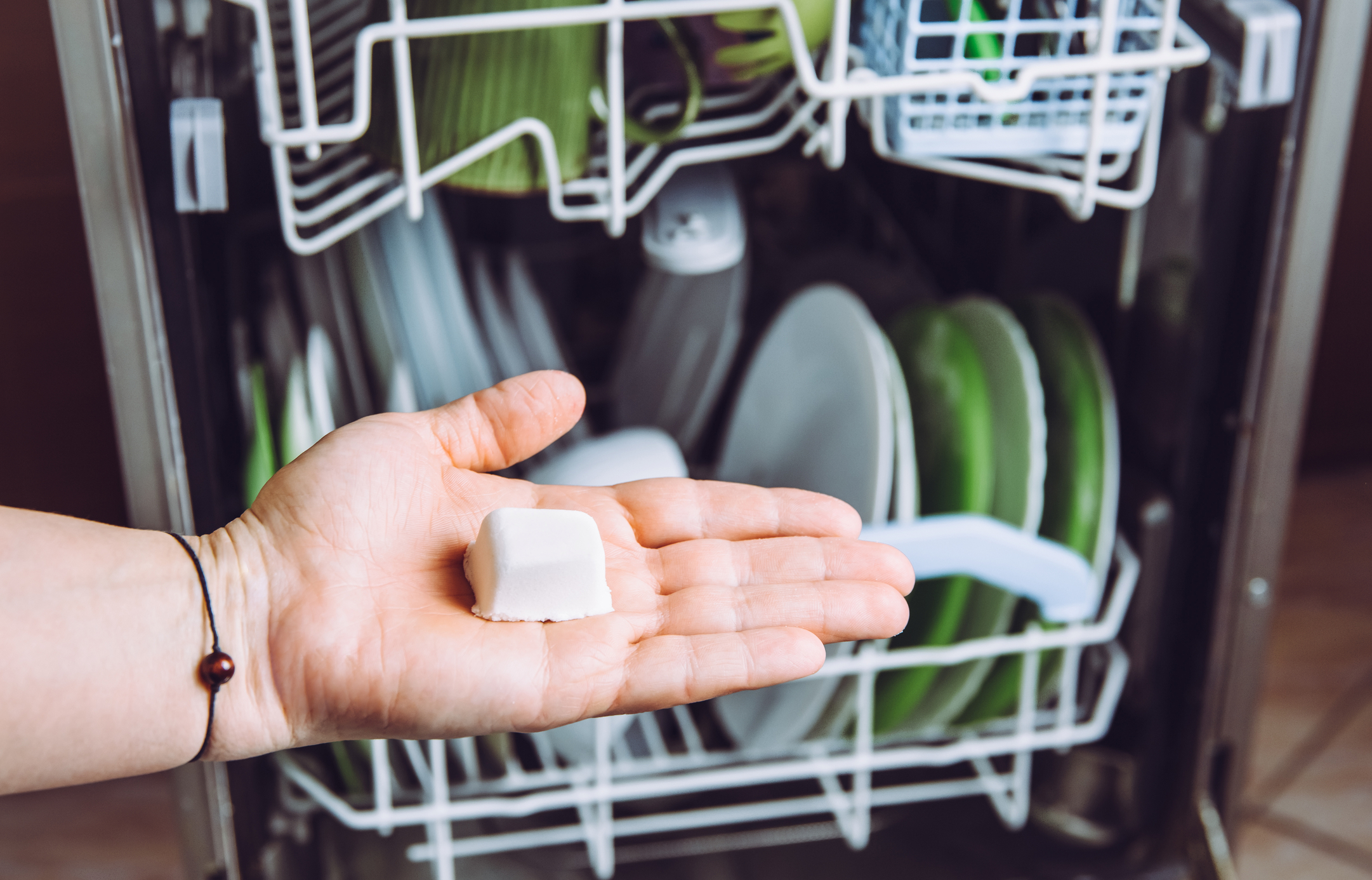 A woman starting washing her dishes with homemade dishwasher detergent tabs