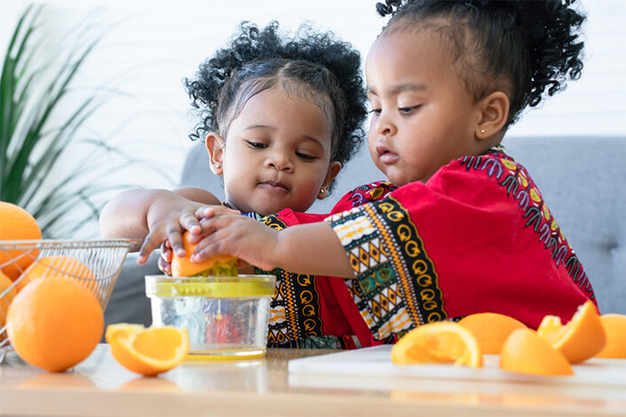 Happy children playing with citrus fruits